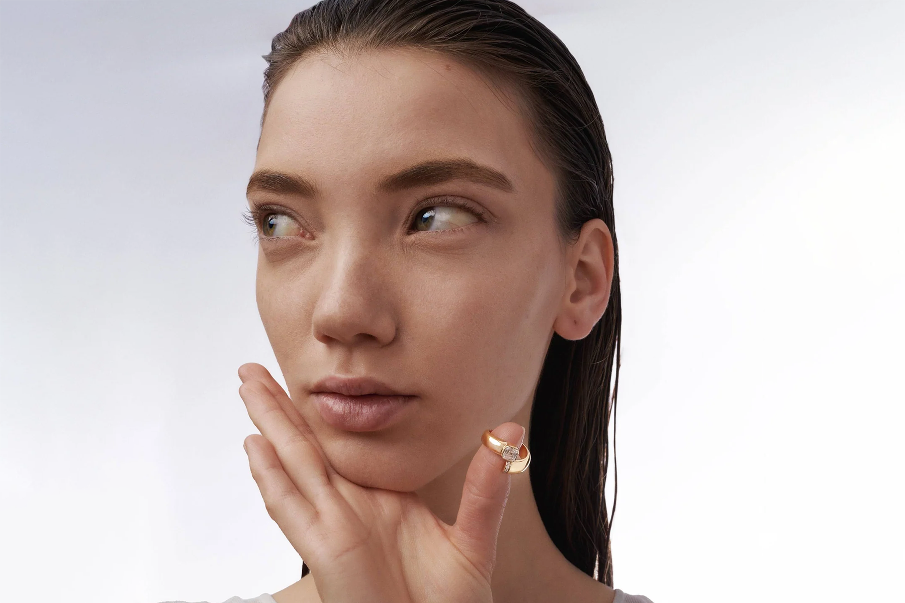 woman with a asscher cut diamond ring around her thumb