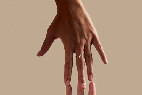A woman with a marquise cut diamond ring around her finger