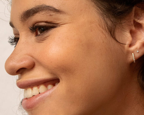 A model wearing Continuous huggies - 14k recycled gold lab-grown diamond earrings from The Future Rocks