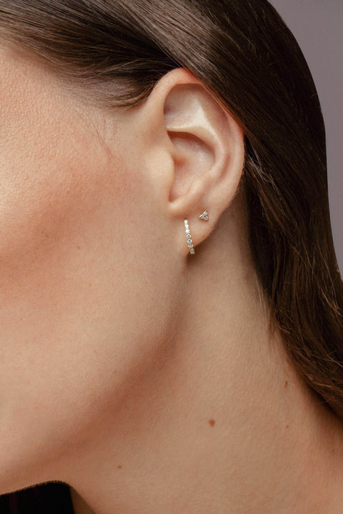 A model wearing Criollas line earrings - 18K recycled gold lab-grown diamond huggie earrings from The Future Rocks