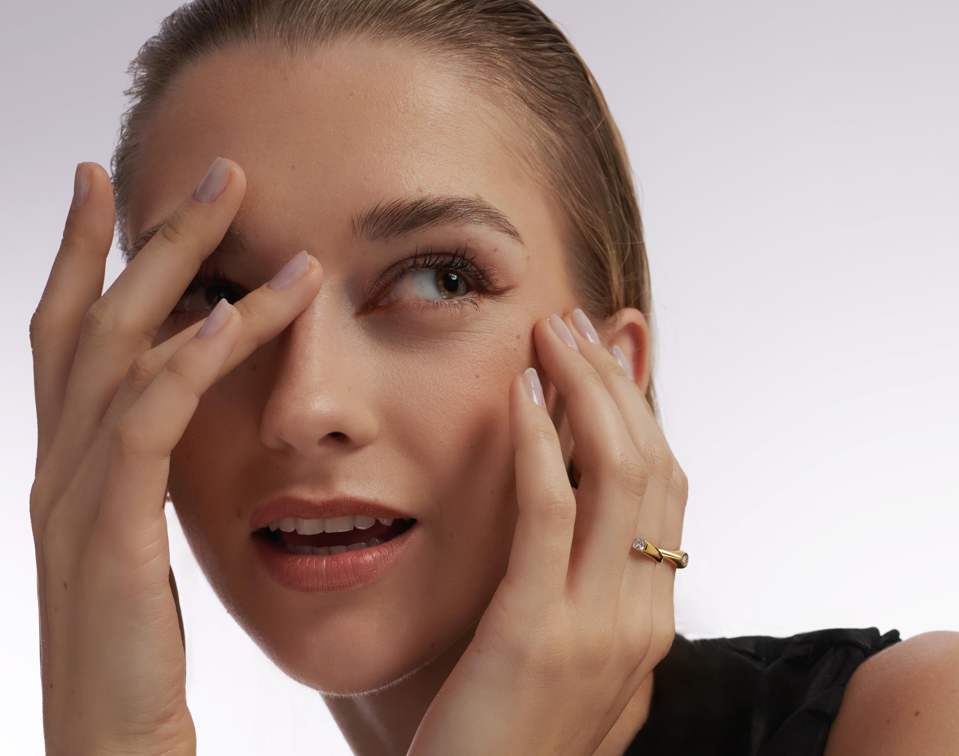 A woman with a emerald cut diamond ring around her finger