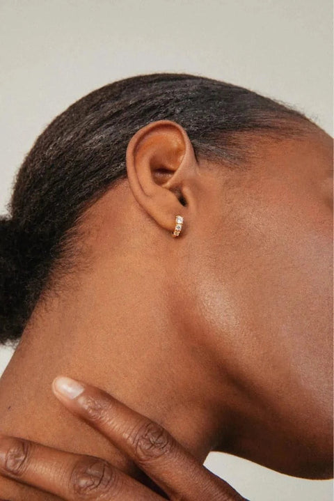 A model wearing Degrade hoops - 18k recycled gold lab-grown diamond huggie earrings from The Future Rocks