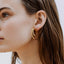 A model wearing Cleopatra double hoop earrings - 9k recycled gold lab-grown diamond earrings from The Future Rocks 
