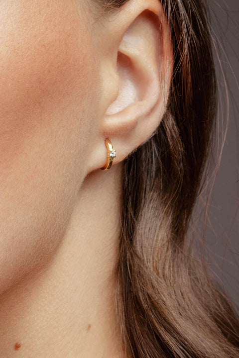 A model wearing Criollas one earrings - 18K recycled rose gold lab-grown diamond huggie earrings from The Future Rocks 